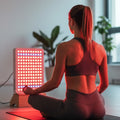 Brightside Longevity Core 750 full spectrum red light therapy panel used during a seated yoga and meditation session in a home wellness space.